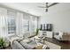 Cozy living room with large windows, comfortable seating, and a ceiling fan at 2420 Lakeshore Se Ln, Atlanta, GA 30316
