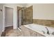 Bright bathroom featuring a soaking tub with shower and tiled surround at 4934 Wyeth Way, Johns Creek, GA 30022