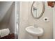 Stylish half bathroom featuring pedestal sink and decorative mirror near staircase at 4934 Wyeth Way, Johns Creek, GA 30022