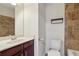 Cozy bathroom featuring a brown tiled shower, white fixtures, and dark vanity at 4934 Wyeth Way, Johns Creek, GA 30022