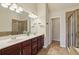 Bathroom with double sink vanity, large mirror, decorative lighting and glass door shower at 4934 Wyeth Way, Johns Creek, GA 30022