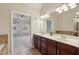 Bright bathroom features double vanity, large mirror, decorative lighting, shower, and views of the bedroom at 4934 Wyeth Way, Johns Creek, GA 30022