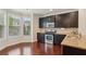 Modern kitchen featuring dark cabinets, granite countertops, and stainless steel appliances at 4934 Wyeth Way, Johns Creek, GA 30022