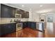 Well-lit kitchen with dark cabinets, stainless steel appliances, open layout to living space at 4934 Wyeth Way, Johns Creek, GA 30022