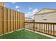 Relaxing outdoor patio area with artificial turf, a wooden privacy fence and views of neighboring townhomes at 4934 Wyeth Way, Johns Creek, GA 30022