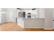 Open concept layout with kitchen island, stainless appliances, and hardwood flooring at 5578 Hedge Brooke Dr, Acworth, GA 30101