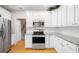 Bright kitchen features white cabinets, stainless steel appliances, and hardwood floors at 5578 Hedge Brooke Dr, Acworth, GA 30101