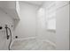Laundry room with gray tiling and plenty of storage with white shelving and cabinets at 5578 Hedge Brooke Dr, Acworth, GA 30101