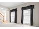 Bright living room featuring large windows with curtains and a staircase view at 5578 Hedge Brooke Dr, Acworth, GA 30101