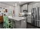 Open kitchen boasts stainless appliances, light gray cabinets, and a large kitchen island at 5135 Arnold St, Covington, GA 30014