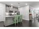 Modern kitchen with stainless steel appliances, island seating, gray cabinets, and hardwood floors at 5135 Arnold St, Covington, GA 30014