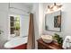 Bathroom with tub, sink on vanity, lighting, and large window with view to outside at 73 Waddell Ne St, Atlanta, GA 30307