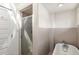 Bright bathroom featuring tub and shower with glass door, white tile surround, and natural light at 73 Waddell Ne St, Atlanta, GA 30307
