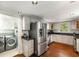 Bright kitchen featuring stainless steel appliances, dark countertops, and hardwood floors, with laundry room at 73 Waddell Ne St, Atlanta, GA 30307