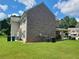 Rear exterior of house with brick and vinyl siding, spacious yard, and covered porch at 828 Cooper Lakes Ct, Grayson, GA 30017