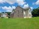 Backyard with spacious lawn and landscaped area, brick and vinyl siding, and mature trees at 828 Cooper Lakes Ct, Grayson, GA 30017