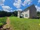 A spacious backyard with lush lawn, mature trees, brick exterior, and vinyl siding at 828 Cooper Lakes Ct, Grayson, GA 30017