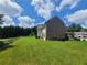 A spacious backyard with lush lawn, mature trees, brick exterior, and vinyl siding at 828 Cooper Lakes Ct, Grayson, GA 30017