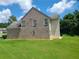 Backyard with spacious lawn and landscaped area, brick and vinyl siding, and mature trees at 828 Cooper Lakes Ct, Grayson, GA 30017