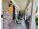 The home's covered front porch has brick accents, green cushioned chairs, and decorative sunflower accents at 828 Cooper Lakes Ct, Grayson, GA 30017