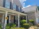 The brick home's inviting front porch features white columns, dark shutters, and pretty landscaping at 828 Cooper Lakes Ct, Grayson, GA 30017