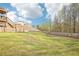 Expansive backyard featuring a lush lawn, framed by a wooden fence, and mature trees in the background at 139 Rushing View Gln, Dallas, GA 30157