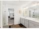 Bright bathroom featuring double sink vanity, framed mirror, wood-look flooring, and a view into the bedroom at 139 Rushing View Gln, Dallas, GA 30157