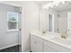 Bright bathroom with double sink vanity, framed mirror, modern lighting, and wood-look flooring at 139 Rushing View Gln, Dallas, GA 30157