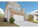 Two-car garage with white doors, stone accents, and a wide driveway leading to a well-maintained yard at 139 Rushing View Gln, Dallas, GA 30157