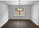 Dining room with hardwood floors, natural light from a large window, and an elegant chandelier at 280 Mcgiboney Ln, Covington, GA 30016