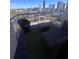 Outdoor condo balcony with synthetic turf, a patio sofa, chair, table and panoramic city views at 285 Centennial Olympic Park Dr # Ph 1-4, Atlanta, GA 30313