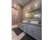 Modern bathroom with double vanity, large lighted mirror, stone tile, and a frameless glass walk-in shower at 285 Centennial Olympic Park Dr # Ph 1-4, Atlanta, GA 30313