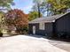 Exterior side view of the house with a large concrete driveway and a small garden area at 4449 Lashley Dr, Tucker, GA 30084