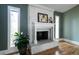 Close-up of white fireplace with mantle, narrow sidelight windows, and hardwood floors at 4449 Lashley Dr, Tucker, GA 30084