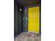 Close-up of modern yellow front door with stone entryway at 4449 Lashley Dr, Tucker, GA 30084