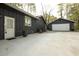 View of the house with a large driveway leading to a detached garage with a white door at 4449 Lashley Dr, Tucker, GA 30084
