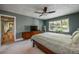 A well-lit main bedroom with a ceiling fan, a large window, and a wood-framed bed at 4449 Lashley Dr, Tucker, GA 30084