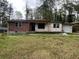 Charming single-story brick home with a covered entrance and an attached one car garage, surrounded by mature trees at 852 Laurelmont Dr, Atlanta, GA 30311