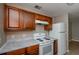 This kitchen features wooden cabinets, white countertops, and a white refrigerator and oven at 10104 Fairington Ridge Cir, Lithonia, GA 30038