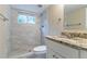 Bathroom featuring a granite countertop, a shower with white marble tiling, and window for natural light at 3891 Northstrand Dr, Decatur, GA 30035