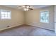 Bedroom with a ceiling fan, two windows, and plush carpet at 3891 Northstrand Dr, Decatur, GA 30035