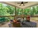 Relaxing covered back porch with ceiling fan offers wooded views and comfortable wicker seating at 7580 Sunridge Ln, Douglasville, GA 30135