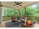 Relaxing covered back porch with ceiling fan offers wooded views and comfortable wicker seating at 7580 Sunridge Ln, Douglasville, GA 30135