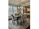 Bright dining area with elegant table setting, coffered ceiling, and scenic backyard view at 7580 Sunridge Ln, Douglasville, GA 30135