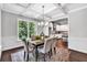 Elegant dining room featuring coffered ceilings and seamlessly connected to a modern, white kitchen at 7580 Sunridge Ln, Douglasville, GA 30135
