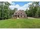Charming two-story brick home with a covered front porch, large windows, and a lush green lawn at 7580 Sunridge Ln, Douglasville, GA 30135