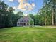 Gorgeous brick home boasts a large, well-maintained front yard in a serene, wooded neighborhood at 7580 Sunridge Ln, Douglasville, GA 30135