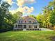 Beautiful brick home with a covered porch and lush green lawn in a wooded setting at 7580 Sunridge Ln, Douglasville, GA 30135