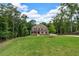 Spacious two-story brick home nestled on a large lot surrounded by mature trees and lush green grass at 7580 Sunridge Ln, Douglasville, GA 30135