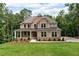 Beautiful two-story brick home with a welcoming front porch and a well-manicured lawn surrounded by lush trees at 7580 Sunridge Ln, Douglasville, GA 30135
